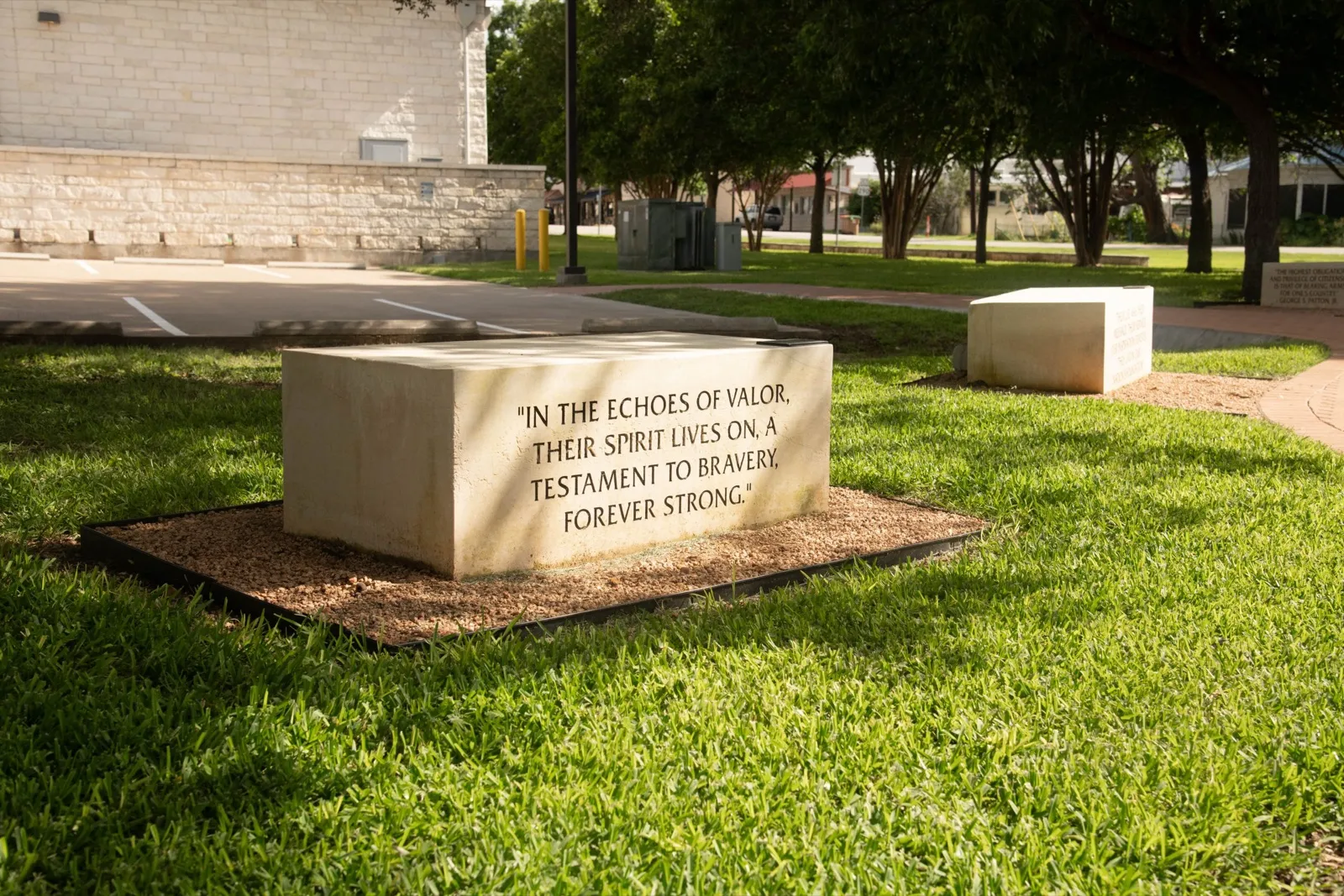 A memorial bench engraved with a dedication, set in the grass at the memorial