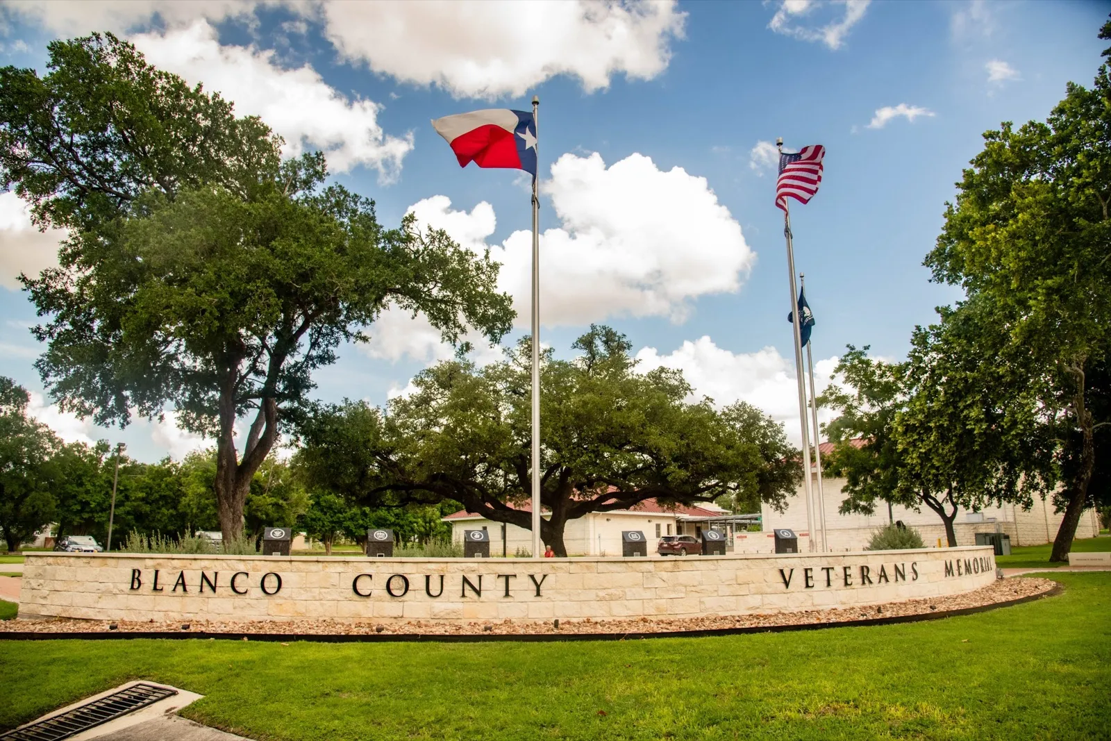 The Blanco County Veterans Memorial wall and flags on a summer day